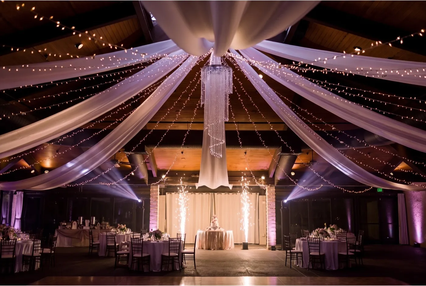 McCormick Ranch Golf Club pavilion at night in deep plum light with moving-head beams and cold spark fountains