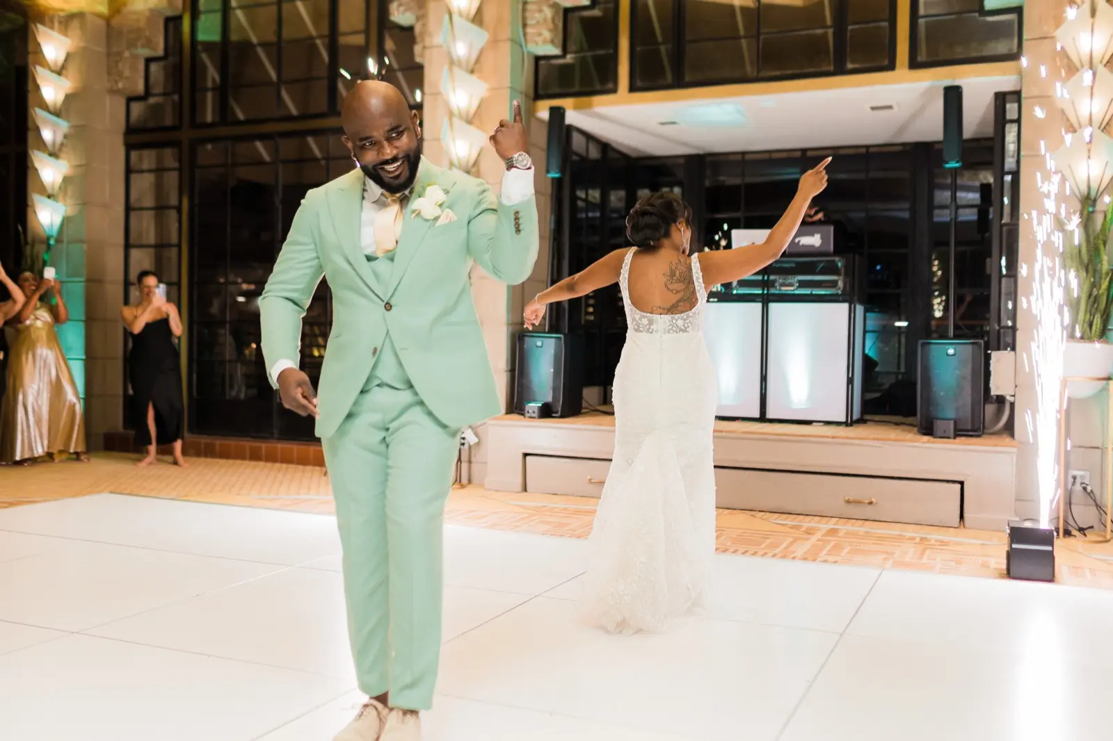 Bride and groomsmen dancing under string lights